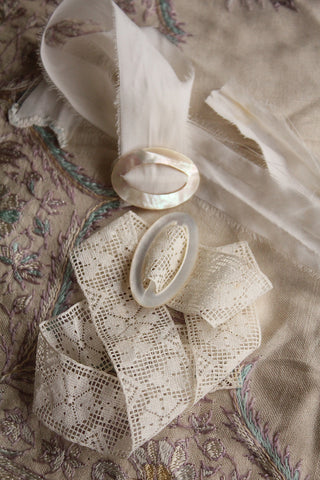 A Pair of Mother of Pearl Buckles on Silk & Lace